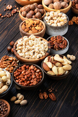 Nuts in assortment, Walnuts, pecans, almonds and other. Healthy food snack mix on wooden table background, top view