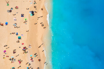 Fototapeta na wymiar People relaxing on the beach during their vacation. Blue sea water. Summer landscape from drone. Aerial landscape.