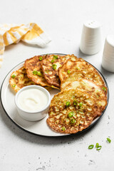 Fluffy zucchini fritters with yogurt sauce. Space for text.