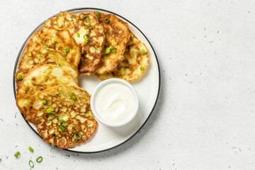 Spicy vegan vegetable pancakes with yogurt sauce. Space for text.