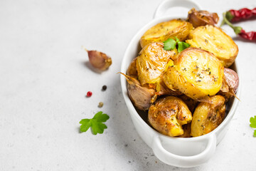 Roasted garlic smashed baked potatoes in baking dish. Top view, copy space.