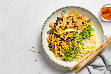 Spicy stir fry vegetabl mix with noodles in a bowl. Top view, copy space.
