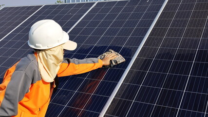 Cleaning of solar panels. A woman hands with a towel to clean the dirty solar panels with dust and...