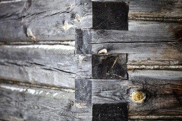 weathered surface of the old wooden log house wall close-up. log walls texture close up. Wooden Log cabin wall in snow close up. The frame of a wooden blockhouse. Vintage log wall surface full frame.