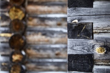 weathered surface of the old wooden log house wall close-up. log walls texture close up. Wooden Log cabin wall in snow close up. The frame of a wooden blockhouse. Vintage log wall surface full frame.