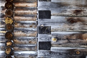 weathered surface of the old wooden log house wall close-up. log walls texture close up. Wooden Log cabin wall in snow close up. The frame of a wooden blockhouse. Vintage log wall surface full frame.