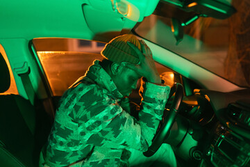 Depression. Young depressed african man sitting at driver seat, thinking about money problems....