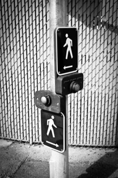 two pedestrian crossing buttons in the street in black and white photo