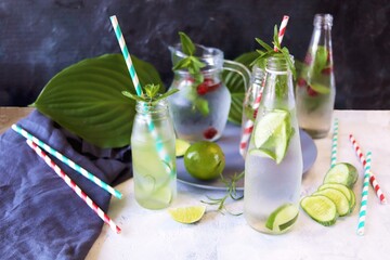 A variety of refreshing detox drinks made from organic fruits, ice, raspberries, cucumbers, lime and mint leaves, on the kitchen table, summer, healthy food, slimming water