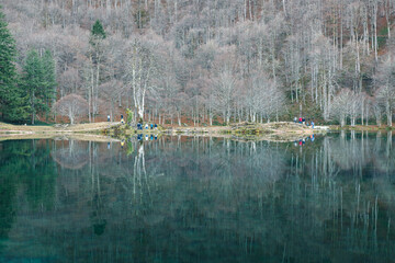 Vue sur le lac de Bethmale en hiver, réflexion sur l'eau et promeneur.