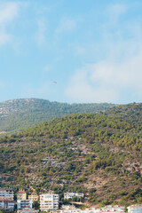 Turkey: view of the city in the mountains and the sea. skydiver on the background