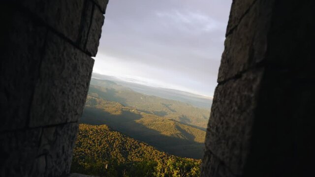 The camera flies through the span of an ancient tower showing a mountain landscape. Very beautiful shots