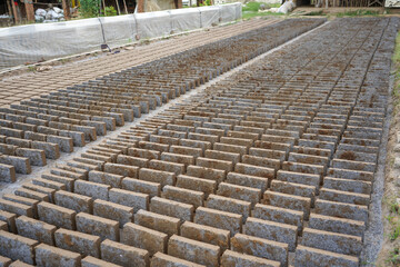 Fototapeta premium Making bricks from clay. After the clay is molded into bricks, after that it is laid out and dried in the yard in the sun before being burned to make it hard and dry.