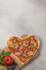 Pizza in the shape of a heart on a plate for Valentine's day with ingredients