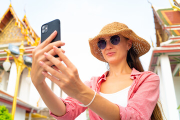 Happy young samrt women take selfie photo while trael in buddhist temple