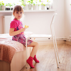 child girl eats pizza and looks