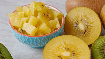 Golden kiwifruit chopped chunks in a bowl. Fresh kiwi fruit salad snack.