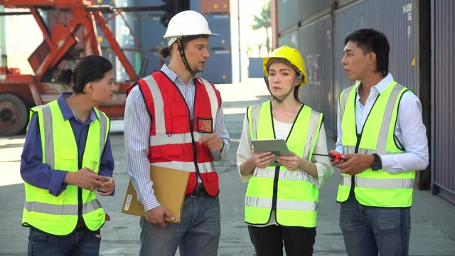 diversity worker foreman and secretary using document file meeting with worker to checking  control loading Containers box at warehouse logistic in Cargo freight ship for import export in harbor.