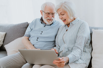 Elderly couple with computer laptop at home