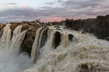 Water rushing down the Augrabies falls at sunset. The Orange river is in flood during January 2022