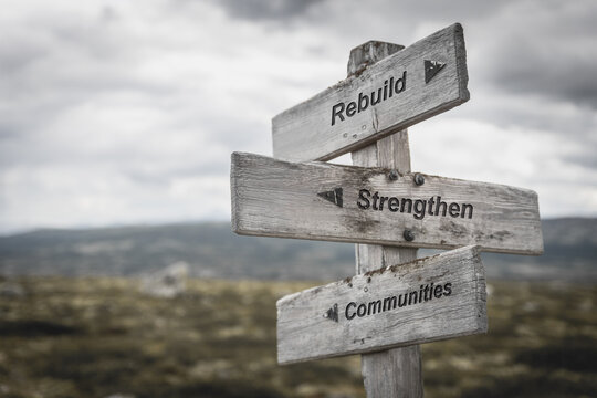 rebuild strengthen communities text quote signpost outdoors in nature.