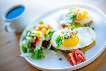 Breakfast with fried eggs on toasts on a restaurant table