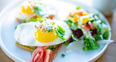 Breakfast with fried eggs on toasts on a restaurant table