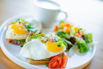 Breakfast with fried eggs on toasts on a restaurant table