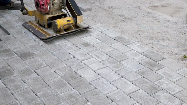 Machine for compaction, vibrating plates on paving stones. The concept of laying paving slabs and paving stones