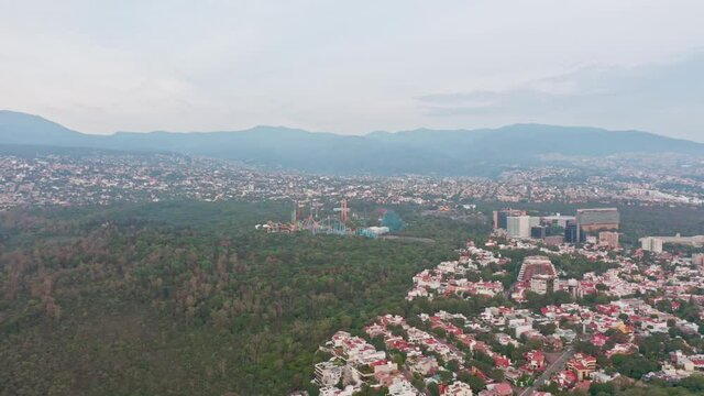 Aerial flying over a Forest Neighbourhood at day establishing shot with Six Flags