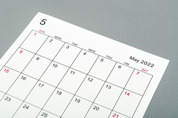 May 2022 calendar sheet on grey background.