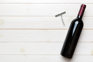 One Bottle of red wine with corkscrew on colored table. Flat lay, top view wth copy space