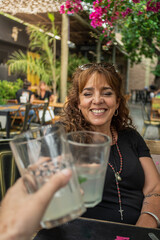 adult woman with curlers toasts with lemonade in the park