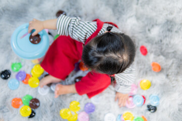 Naklejka premium Happy little girl playing with the developmental toys, Asian girl, cute kid.