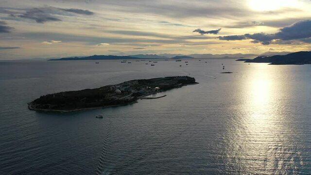 Aerial drone video from island of Psitaleia the largest sewage treatment plant in Europe, Saronic gulf at sunset, Peiraeus, Attica, Greece