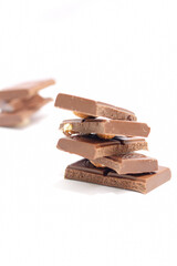 chocolate bars with peanuts, almonds and dried beans on a white background