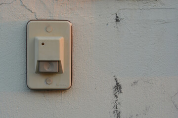 White doorbell on the old wall of the house.
