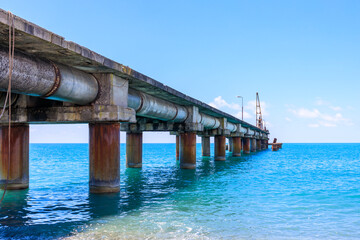Obraz premium view of the sea pier going into the distance, blue sea in daylight