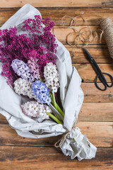 Blumenstrauß mit Hyazinthen und Schleierkraut in Papier verpackt, Blumen im Frühling