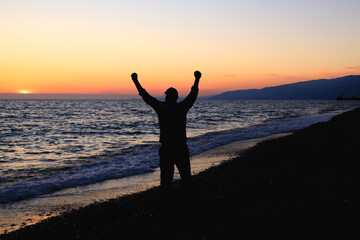 Fototapeta na wymiar silhouette of a man on the seashore, the sea coast stretching into the distance