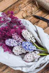 Blumenstrauß mit Hyazinthen und Schleierkraut in Papier verpackt, Blumen im Frühling