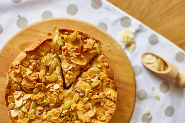 Apple or pear pie, tart with caramel nuts on wooden table, copy space, top view.