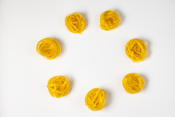 few homemade fettuccine nest in a shape of circle isolated on white background