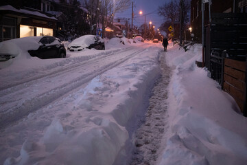 Toronto, Ontario / Canada - January 17, 2022 - Person walking in Toronto St Clair West on day of snowstorm