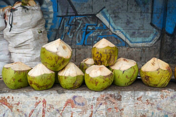 Pile of young coconuts in iron wire baskets ready for sale in the summer. Its fresh taste is...