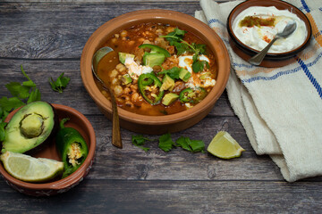 Poblano hominy bowl- vegetarian mexican lunch. Served with cream, avocado, sliced jalapenos.