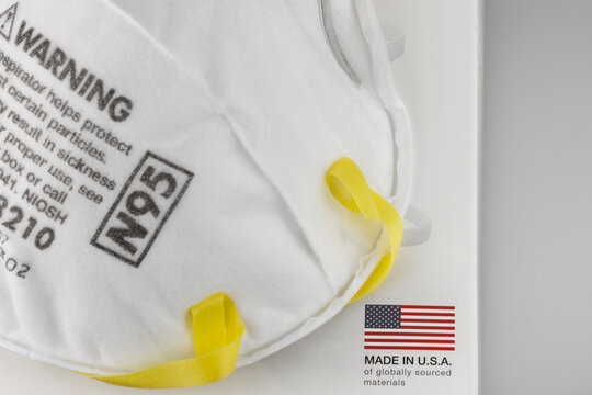 An N95 Face Mask On A Box With An Made In USA Of Globally Sourced Materials Label, On A White Background