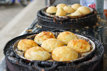 The process of making quail egg mini martabak. one of the street food in Indonesia. This snack consists of flour dough, sliced ​​scallions. Cooked in a frying pan with a small round pattern.