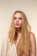 Naklejka premium White young woman with blonde hair isolated on beige in beige blazer
