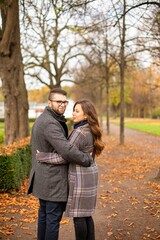 Walking young european married couple in park in fall